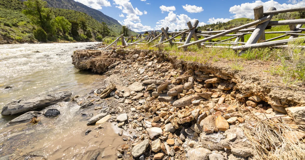 A river in flood spreading over its banks and surrounding ground.