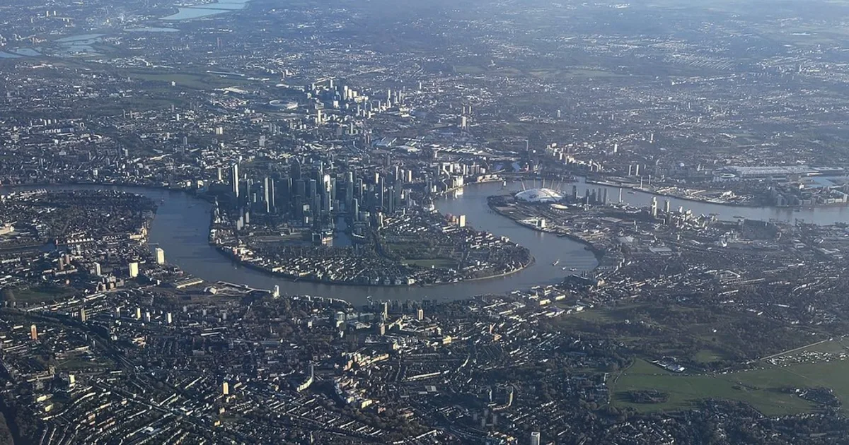 Aerial view of a meandering river winding across a broad floodplain.